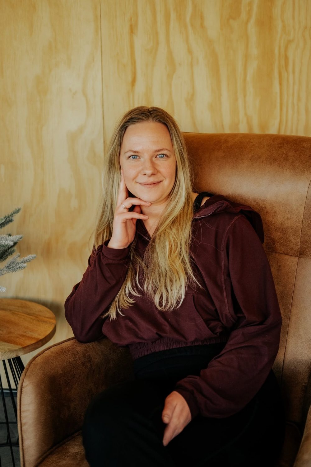 Emily Cozzens, smiling, seated in a leather armchair